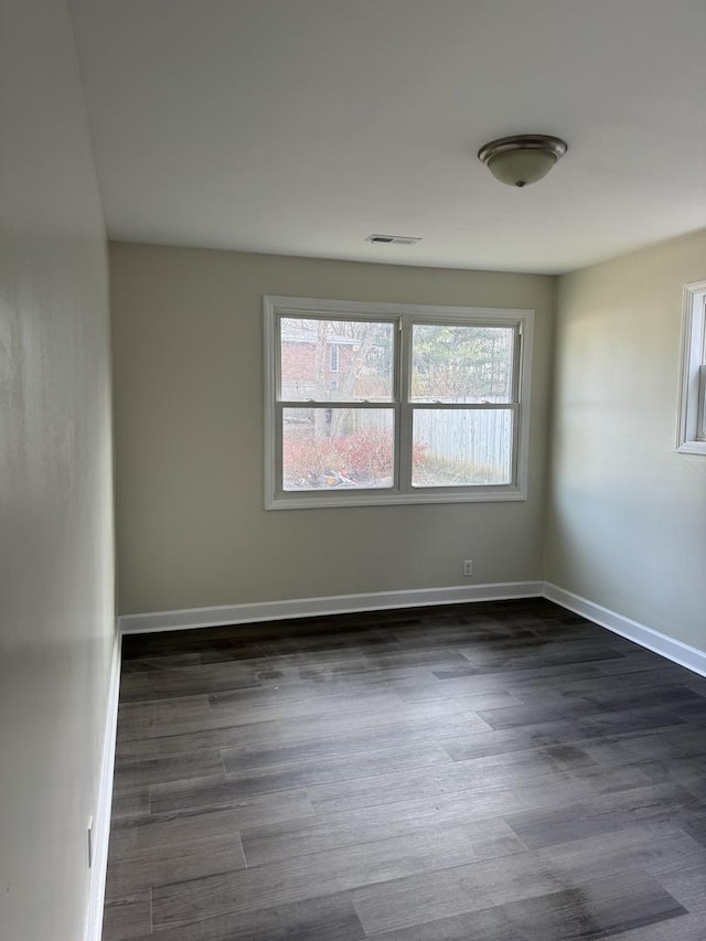 unfurnished room with dark wood-type flooring