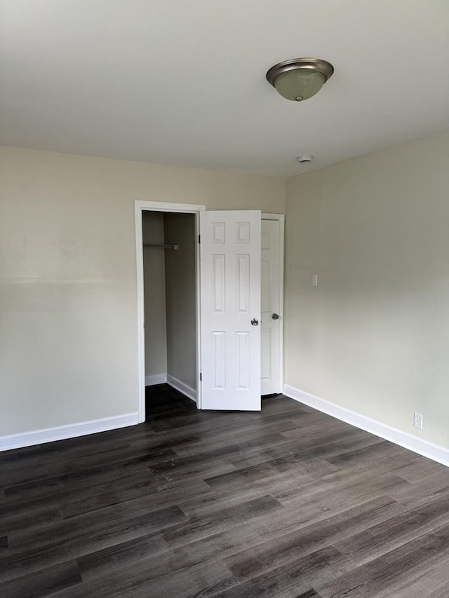 unfurnished room with dark wood-type flooring