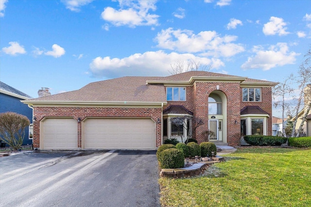 view of front of property with a front yard and a garage