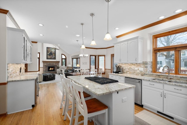 kitchen with pendant lighting, white cabinetry, stainless steel dishwasher, and tasteful backsplash