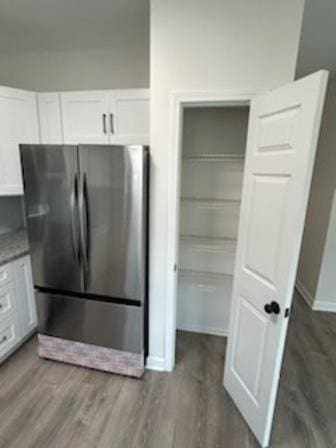 interior space featuring white cabinets, stainless steel refrigerator, and dark wood-type flooring