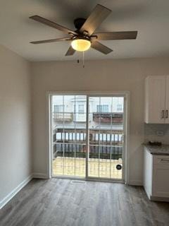 unfurnished dining area featuring ceiling fan and wood-type flooring