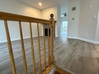 stairway with hardwood / wood-style floors and ceiling fan