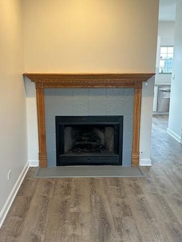 interior details featuring hardwood / wood-style flooring and a tile fireplace