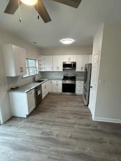 kitchen with ceiling fan, white cabinets, stainless steel appliances, and light hardwood / wood-style floors