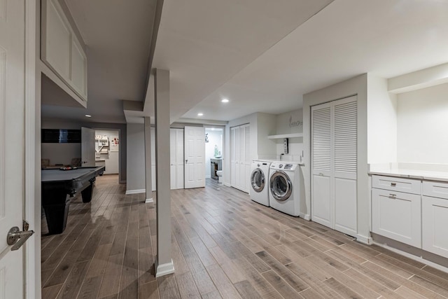 laundry room with light hardwood / wood-style flooring and washer and dryer