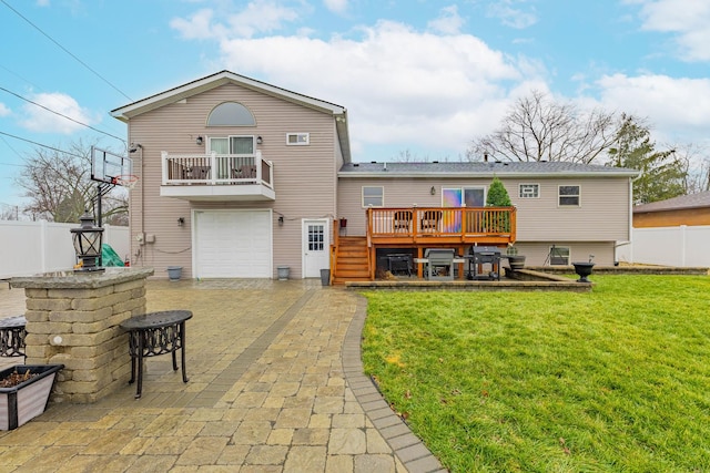 rear view of house with a yard, a balcony, a garage, and a wooden deck