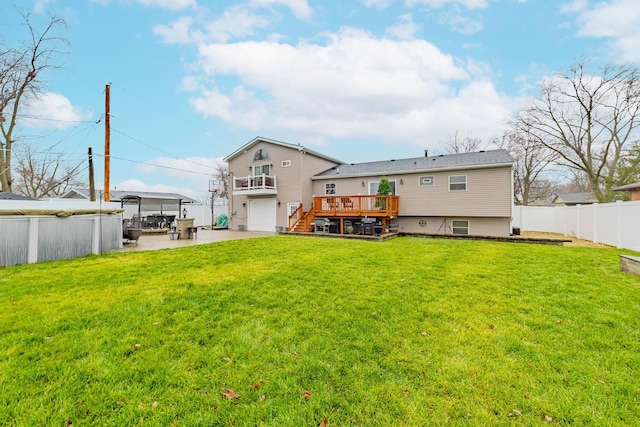 back of property with a deck, a yard, and a patio