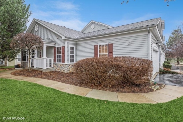 view of front of house featuring a front lawn, a porch, and a garage