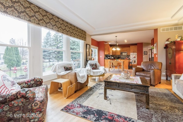 living room featuring light hardwood / wood-style flooring and an inviting chandelier