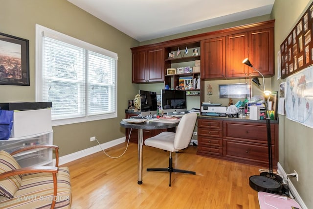 office area featuring built in desk and light hardwood / wood-style flooring