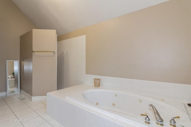 bathroom with tile patterned floors, tiled bath, and vaulted ceiling