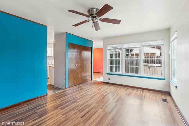 interior space with ceiling fan, a closet, and hardwood / wood-style flooring