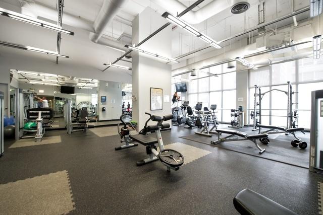 workout area featuring a healthy amount of sunlight, floor to ceiling windows, and a high ceiling