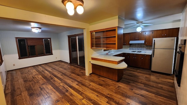 kitchen with ceiling fan, dark wood-type flooring, kitchen peninsula, white appliances, and ornamental molding