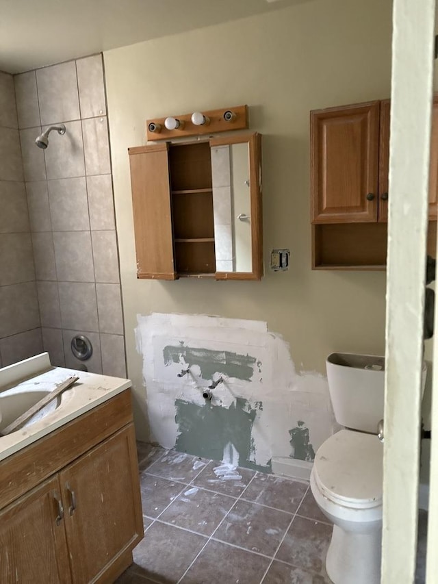 bathroom with tile patterned flooring, vanity, and toilet