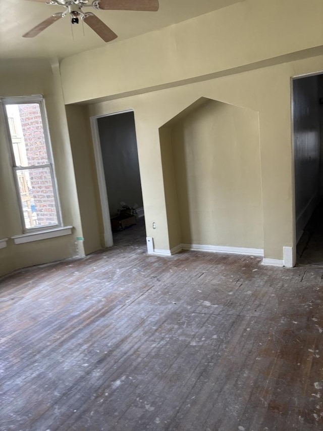 unfurnished room featuring ceiling fan, wood-type flooring, and a wealth of natural light