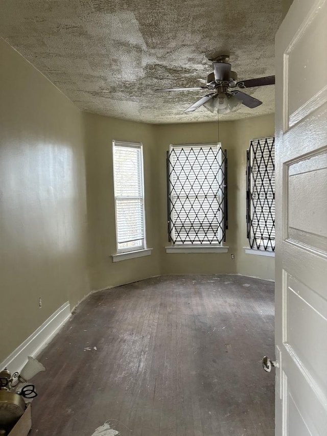 empty room with ceiling fan and hardwood / wood-style flooring