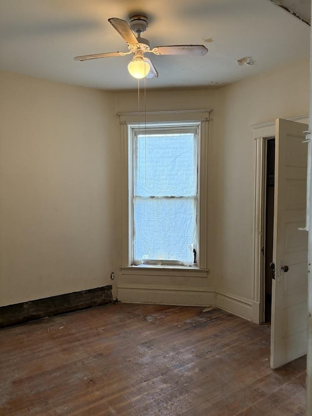 empty room with dark hardwood / wood-style flooring and ceiling fan