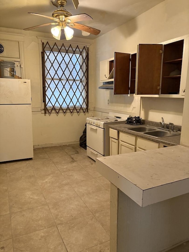 kitchen featuring dark brown cabinets, ceiling fan, sink, and white appliances