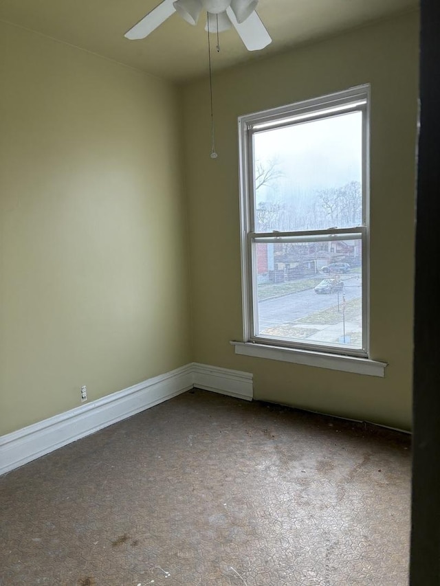 spare room featuring ceiling fan and a wealth of natural light