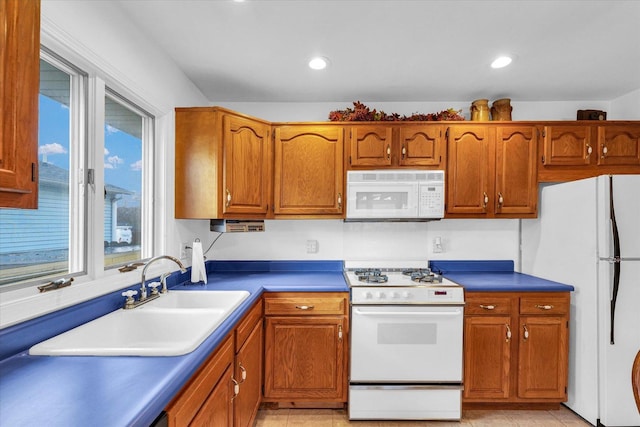 kitchen featuring white appliances, sink, and light tile patterned floors