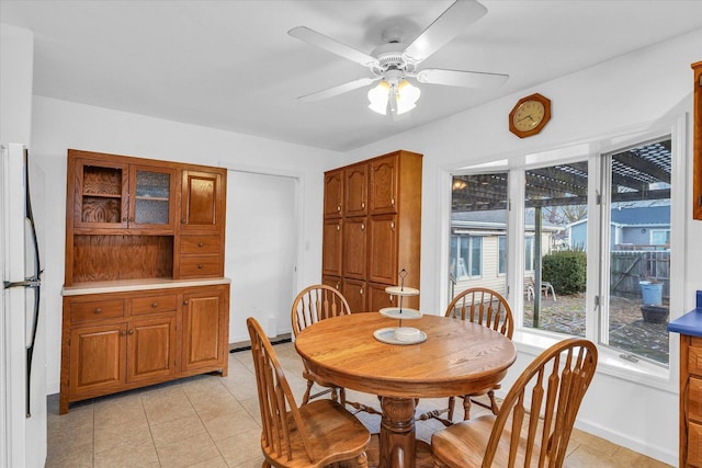 tiled dining area featuring ceiling fan