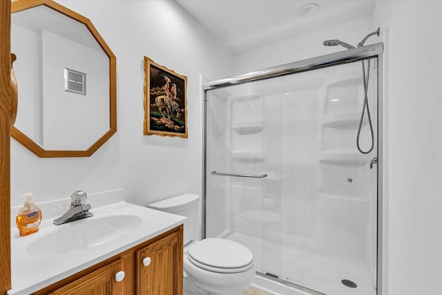 bathroom featuring vanity, toilet, and a shower with shower door