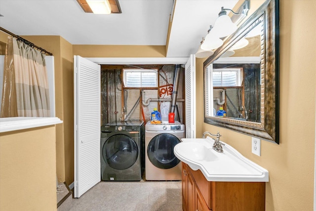 washroom with separate washer and dryer and sink