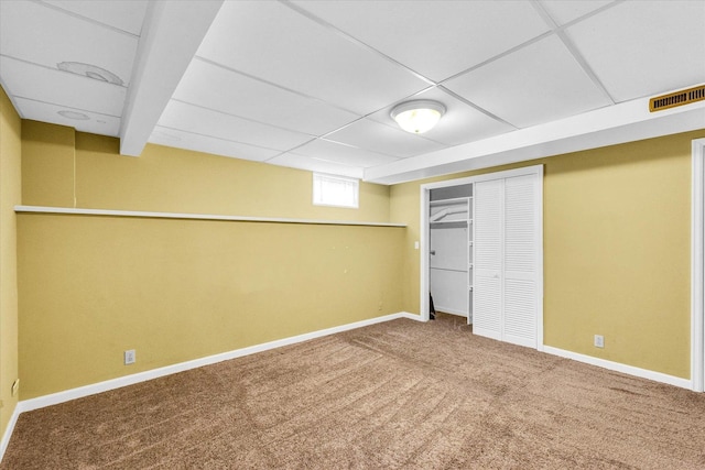 basement featuring carpet flooring and a paneled ceiling