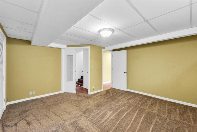 basement with a paneled ceiling and carpet flooring