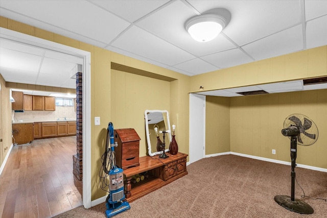 interior space with light carpet, a paneled ceiling, and sink