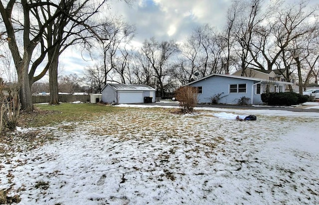 yard layered in snow featuring an outdoor structure and a garage