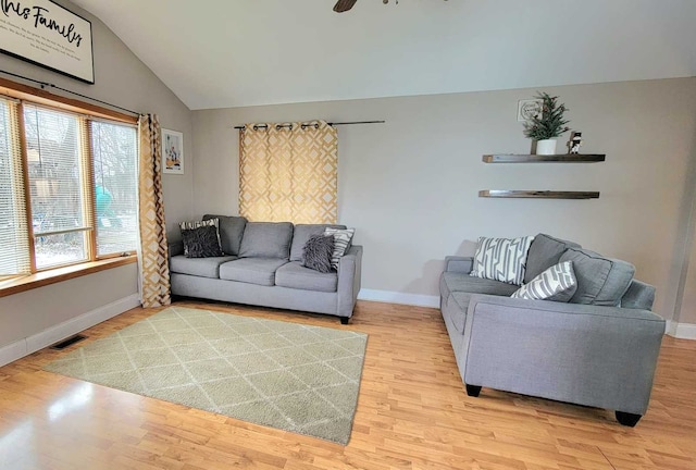 living room with ceiling fan, light hardwood / wood-style flooring, and lofted ceiling