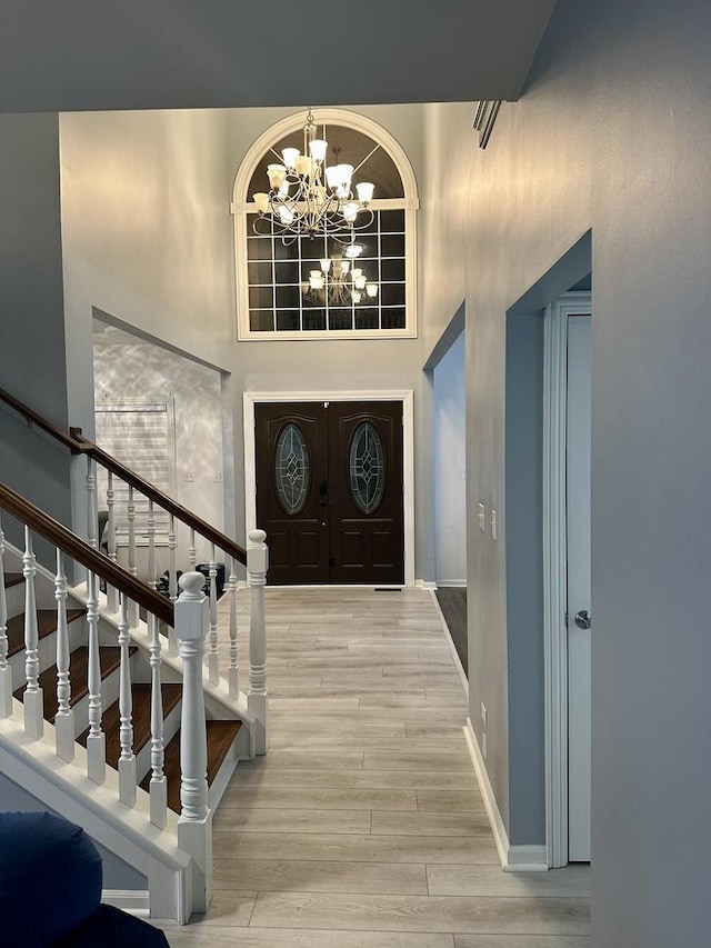 foyer entrance featuring a towering ceiling and a notable chandelier