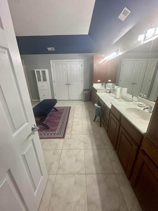 bathroom featuring vanity and lofted ceiling