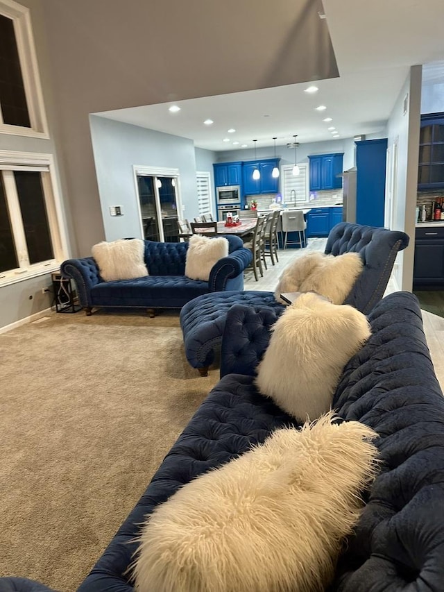 living room with light colored carpet and sink