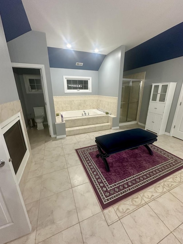 bathroom with separate shower and tub, toilet, and lofted ceiling