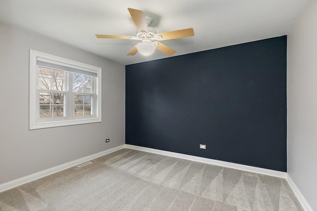 carpeted spare room featuring ceiling fan