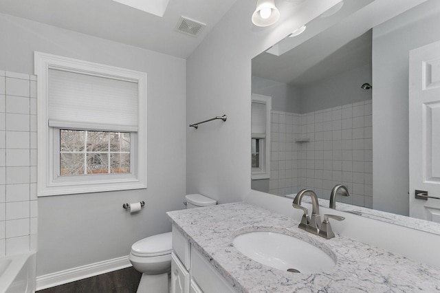 full bathroom featuring hardwood / wood-style floors, vanity, toilet, and tiled shower / bath