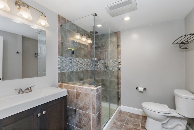 bathroom featuring tile patterned flooring, toilet, vanity, and walk in shower