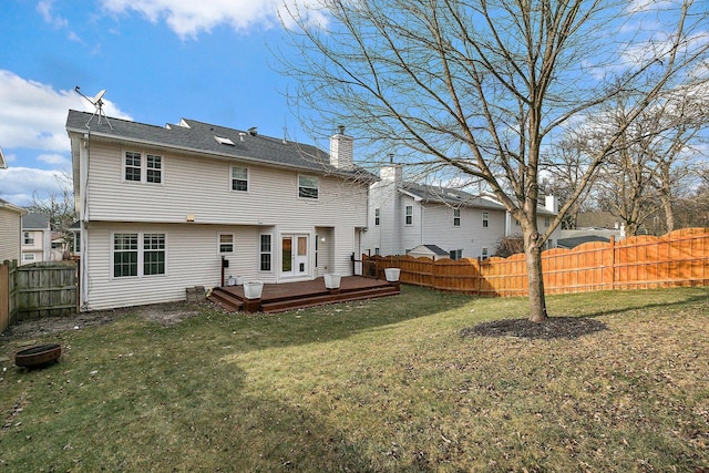 rear view of property featuring a lawn and a deck