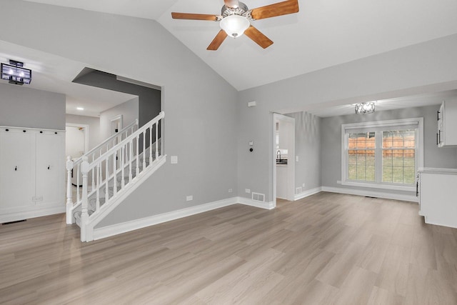 unfurnished living room with vaulted ceiling, light hardwood / wood-style floors, and ceiling fan with notable chandelier