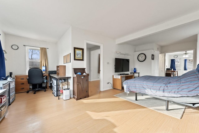 bedroom featuring beamed ceiling and light hardwood / wood-style floors