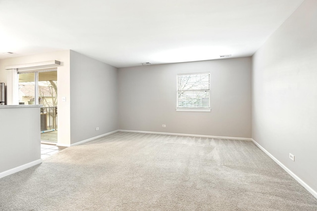 spare room featuring light carpet and a healthy amount of sunlight