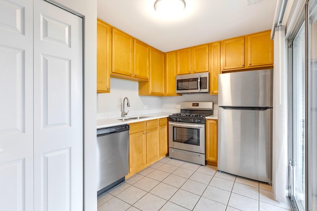 kitchen with sink, light tile patterned floors, and stainless steel appliances