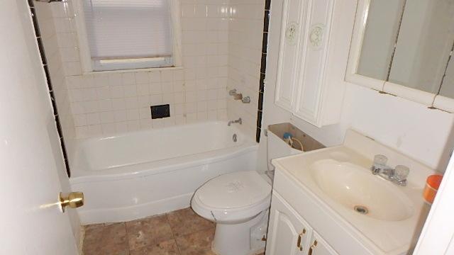 full bathroom with vanity, toilet, and tiled shower / bath