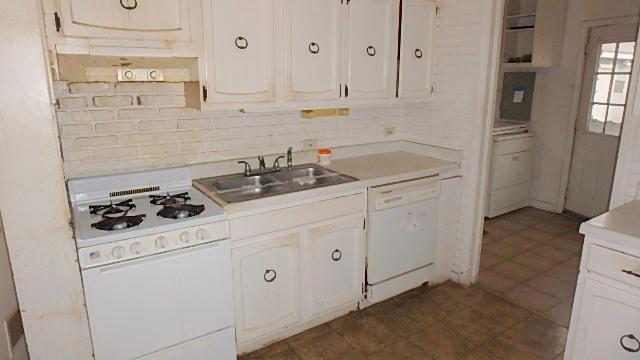 kitchen with white cabinetry, white appliances, and sink