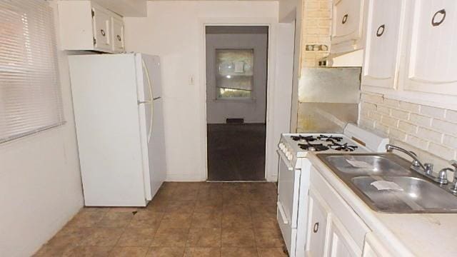 kitchen with backsplash, white cabinetry, white appliances, and sink