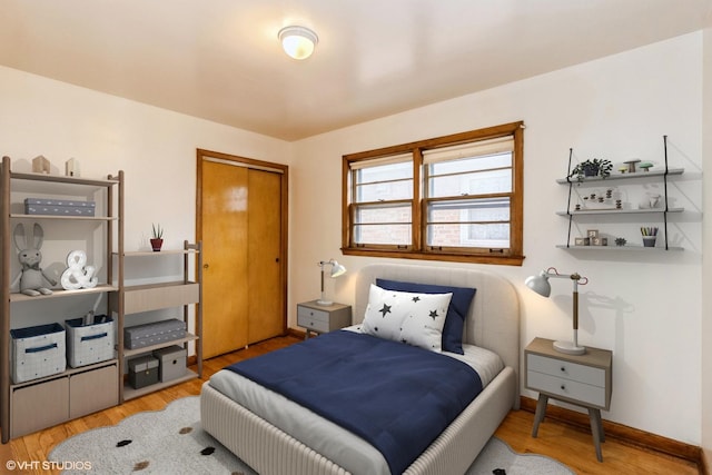 bedroom featuring a closet, wood finished floors, and baseboards